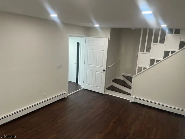 an empty room with wooden floor and white walls