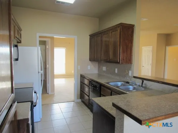a kitchen with a sink a stove and a refrigerator