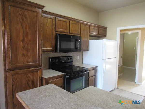 a kitchen with stainless steel appliances a refrigerator stove and microwave