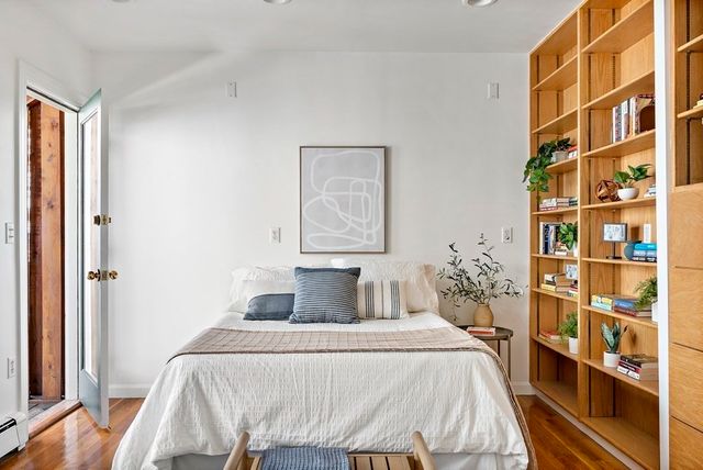 a bedroom with a bed and a book shelf