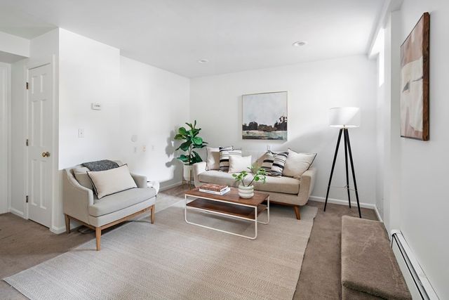 a living room with furniture a rug and a large window