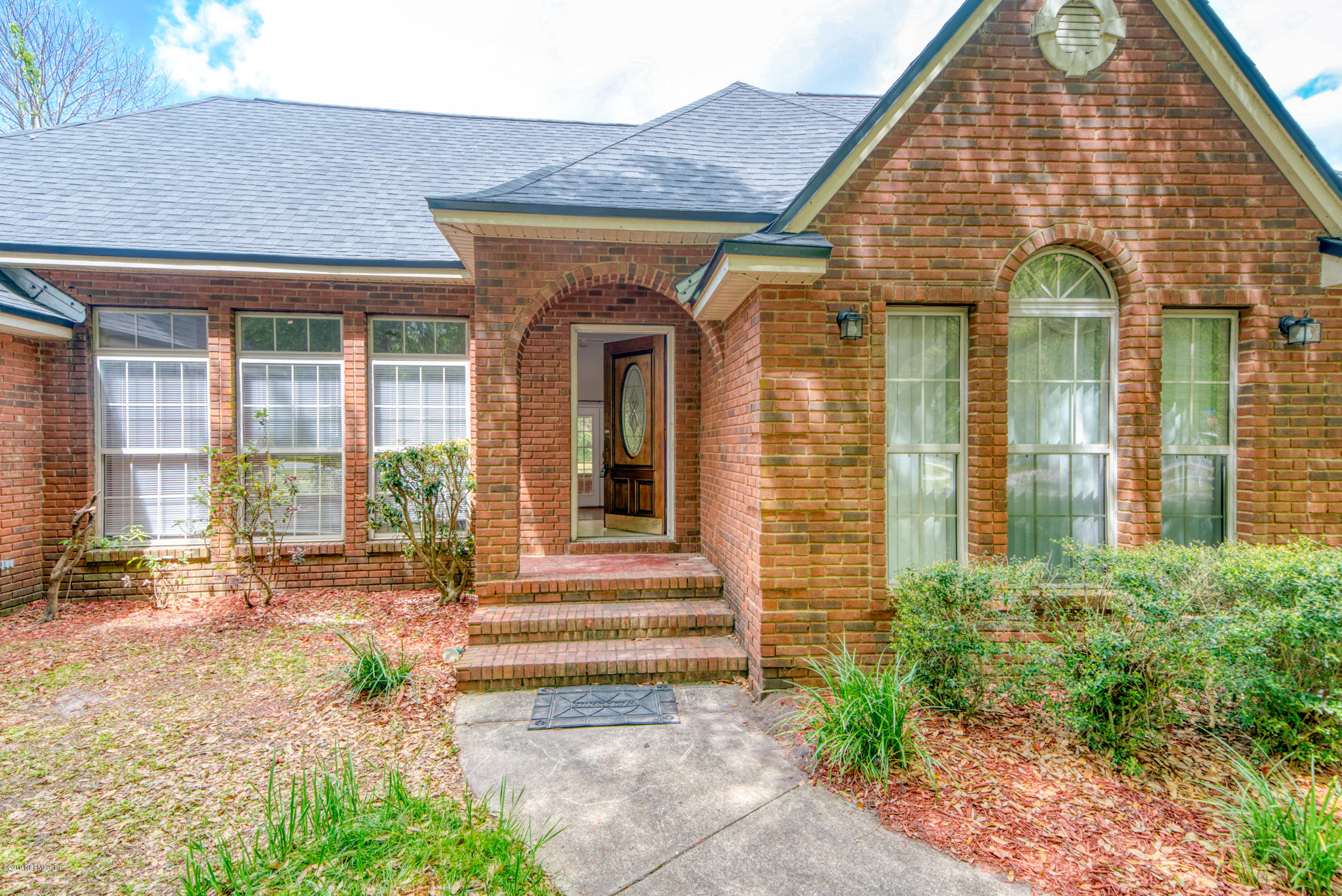 43611 Ratliff Road Callahan, FL 32011 - Photo 3 of 43 a view of a brick house with large windows and plants