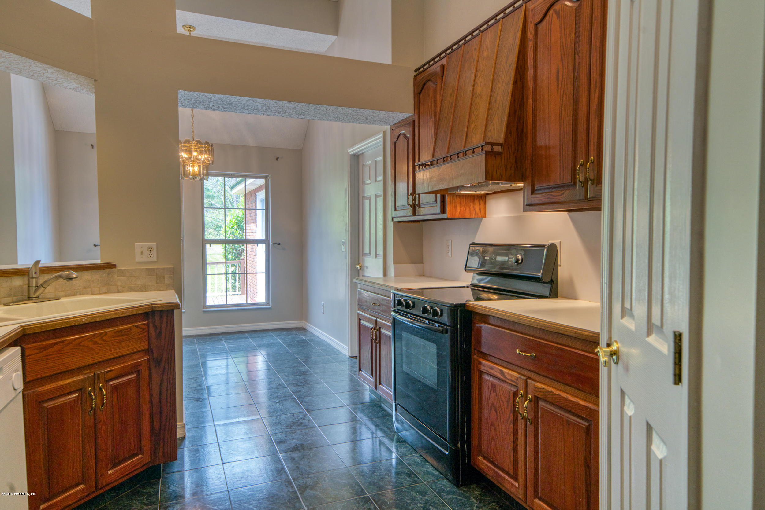 43611 Ratliff Road Callahan, FL 32011 - Photo 38 of 43 a kitchen with granite countertop a stove top oven sink and cabinets