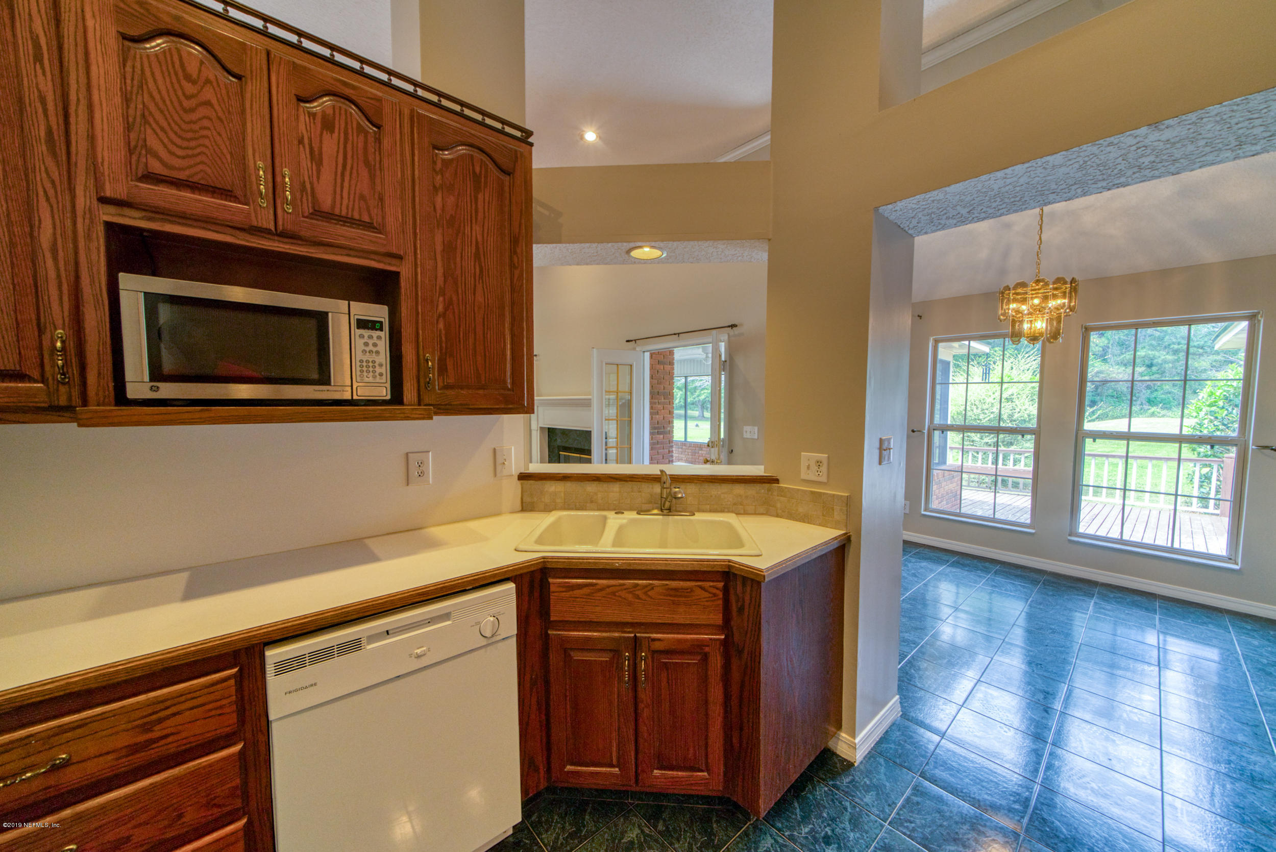 43611 Ratliff Road Callahan, FL 32011 - Photo 41 of 43 a kitchen with stainless steel appliances granite countertop wooden cabinets a sink and dishwasher with wooden floor