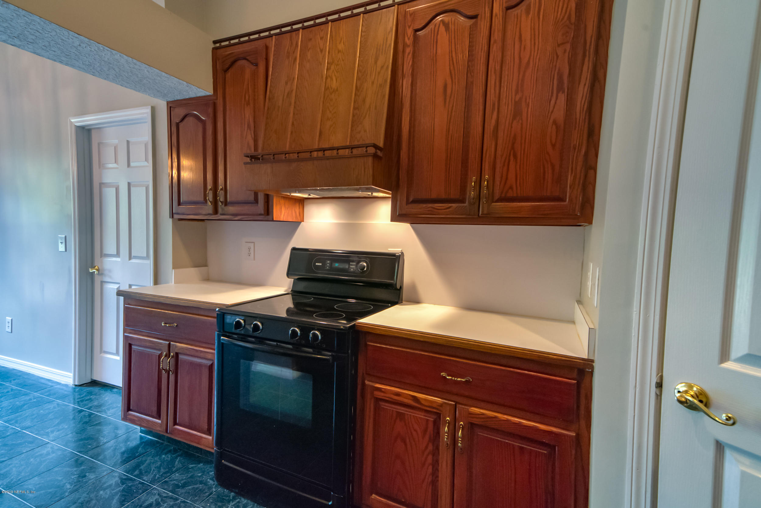 43611 Ratliff Road Callahan, FL 32011 - Photo 42 of 43 a kitchen with a stove and a cabinet