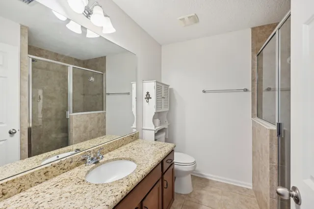 a bathroom with a granite countertop sink toilet and shower