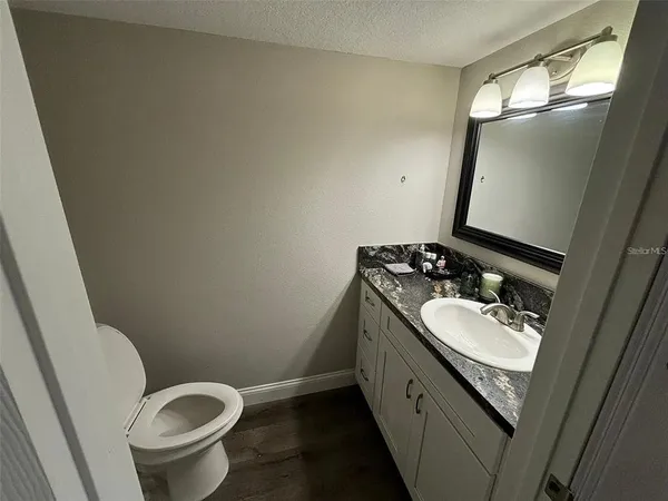 a bathroom with a granite countertop sink and a mirror