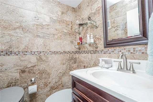 a bathroom with a sink a toilet and a mirror