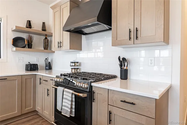 a kitchen with a stove a sink dishwasher a kitchen island with wooden cabinets and floor