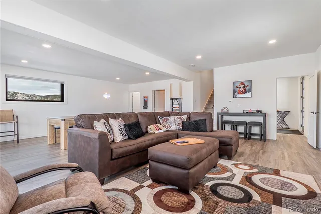 a living room with furniture wooden floor and kitchen view