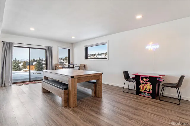 a room with a table chairs and wooden floor