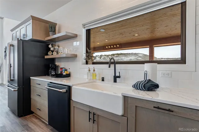 a kitchen with stainless steel appliances a table chairs in it and wooden floors