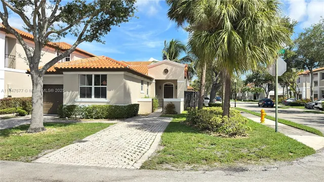 a front view of a house with a yard and potted plants