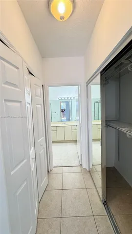 a view of entryway with an empty room and wooden floor