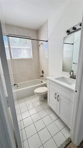 a bathroom with a double vanity sink mirror and toilet