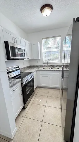 a kitchen with stainless steel appliances a stove sink microwave and cabinets