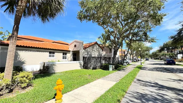 a front view of a house with a yard and potted plants