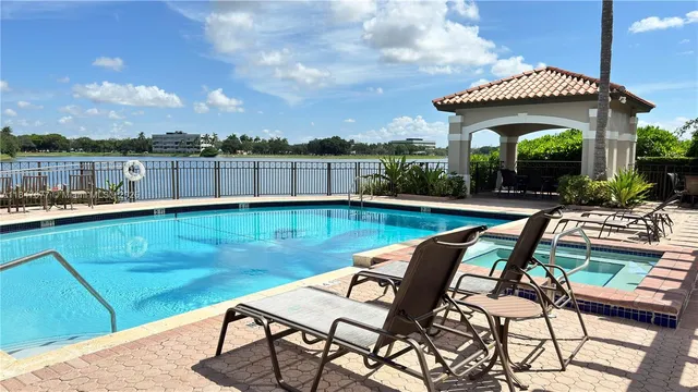 a view of a swimming pool with chairs and table in patio