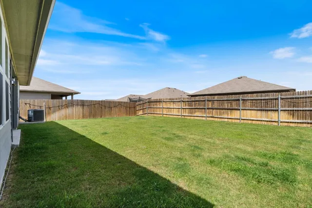 a view of a house with a big yard and a large tree