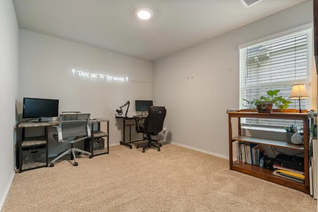 a view of a workspace with furniture and a window
