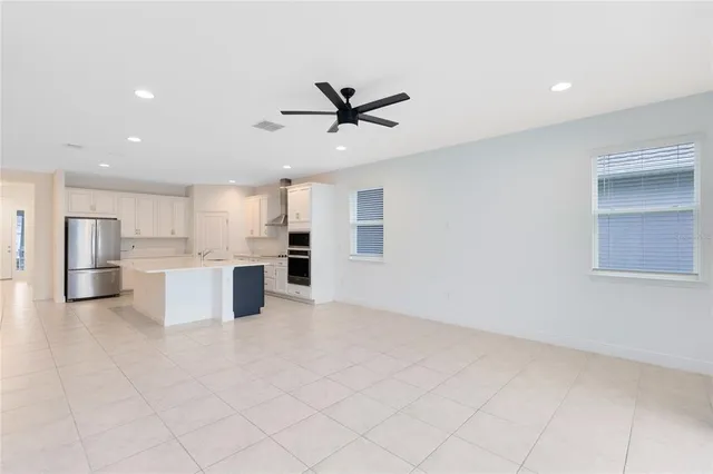 a view of kitchen with a sink stainless steel appliances and cabinets
