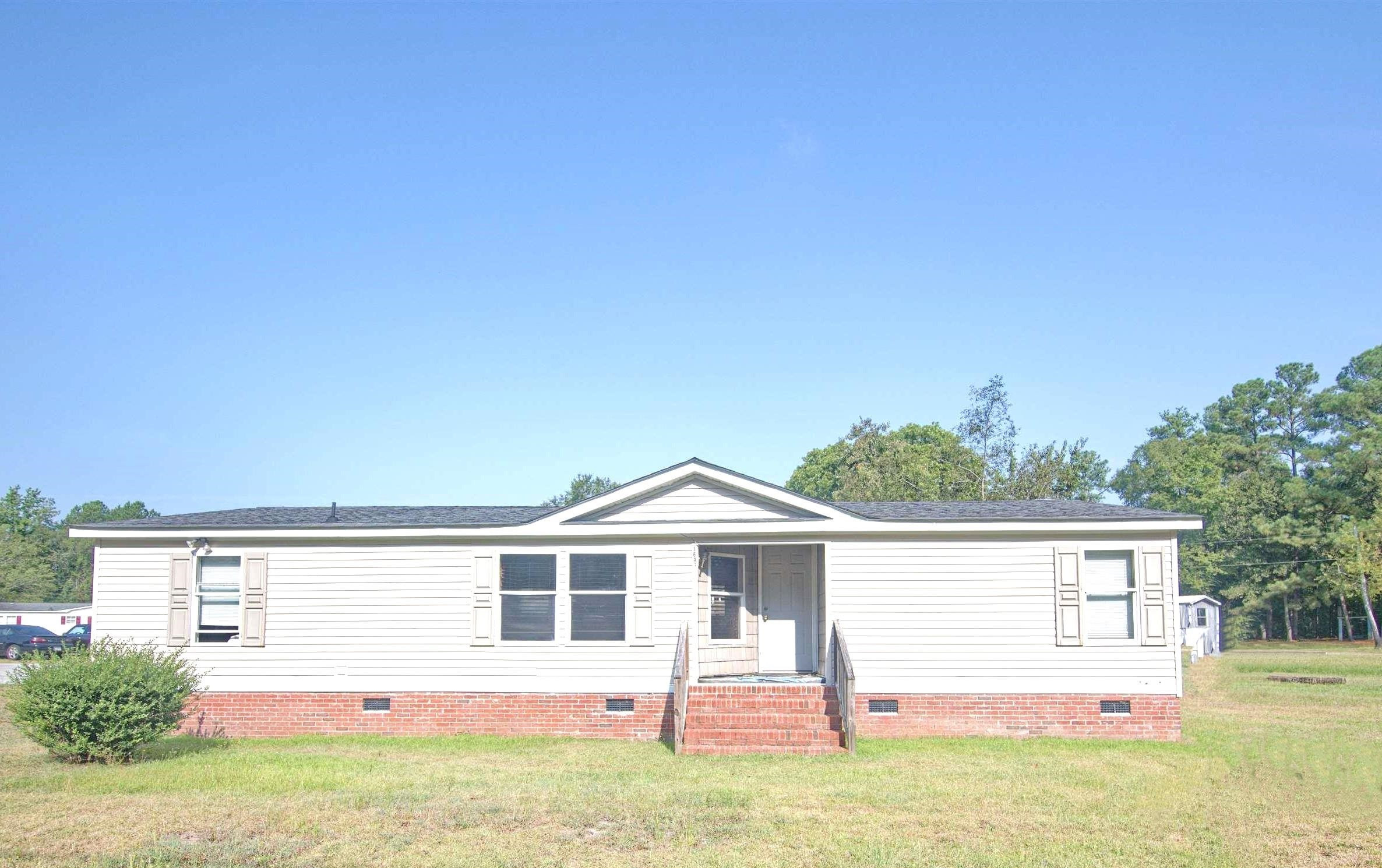 6640 Muscat Road Hope Mills, NC 28348 - Photo 16 of 22 a front view of a house with a yard and garage