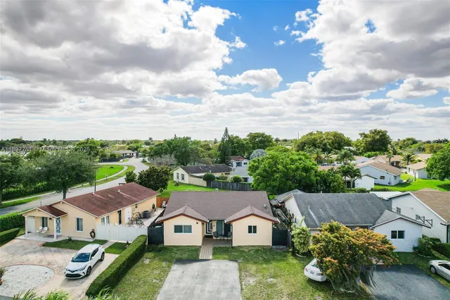 an aerial view of a house with yard and mountain view in back