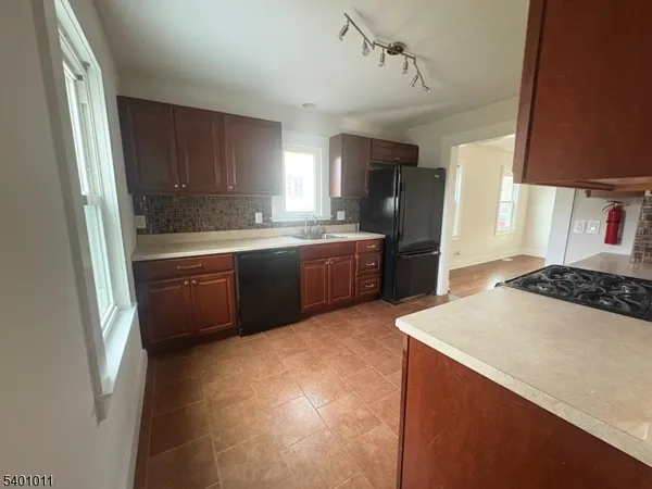 a kitchen with stainless steel appliances a sink a stove a refrigerator and cabinets
