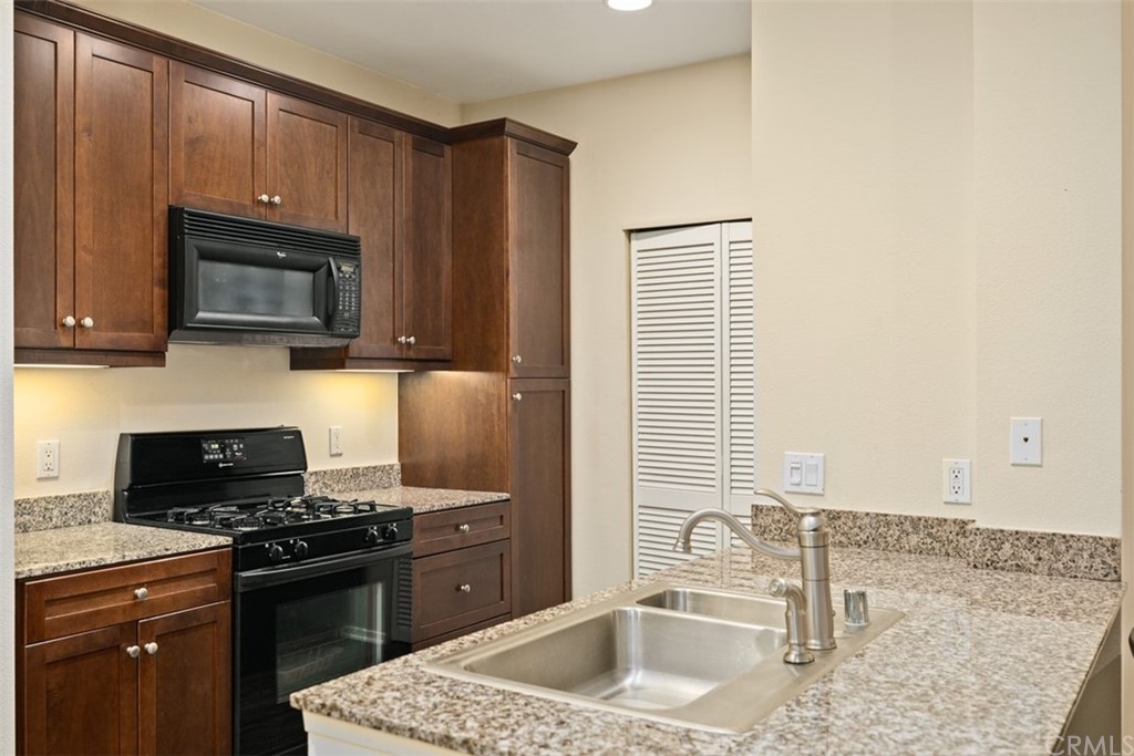 a kitchen with stainless steel appliances granite countertop a sink stove and microwave