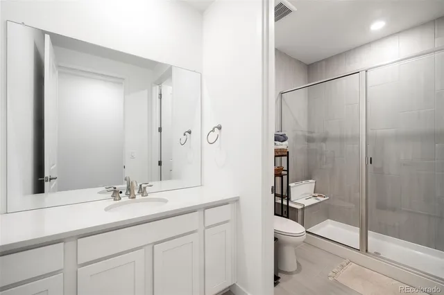 a bathroom with a shower sink mirror and toilet