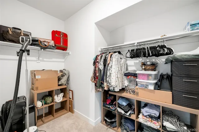 a view of walk in closet with clothes and shoes