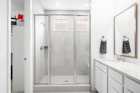 a bathroom with a shower sink and mirror