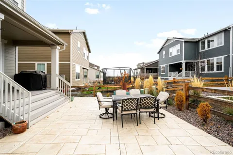 a view of a patio with a dining table and chairs with wooden floor