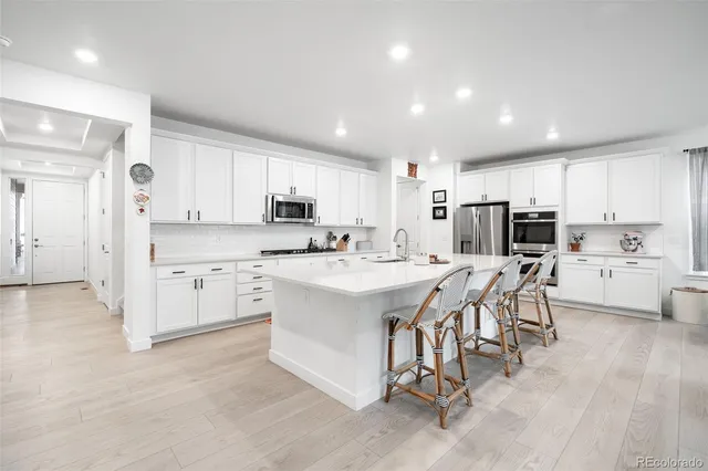 a kitchen with white cabinets and stainless steel appliances