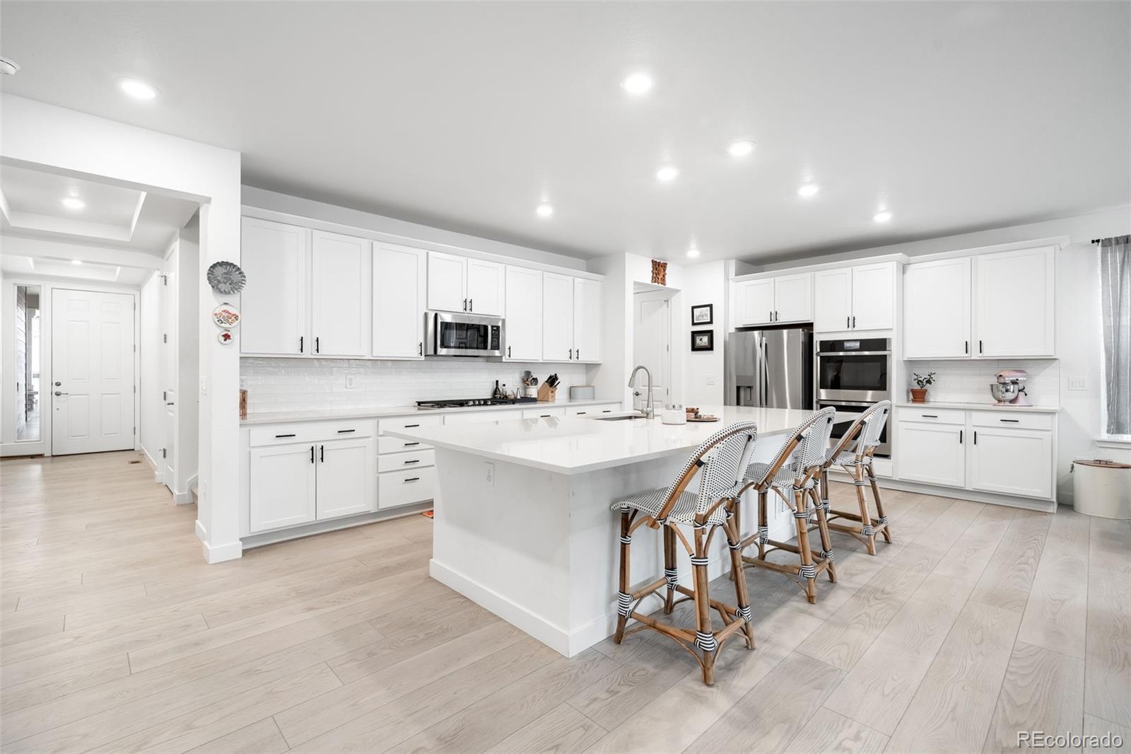 1928 Marlowe Circle West Erie, CO 80516 - Photo 8 of 47 a kitchen with white cabinets and stainless steel appliances