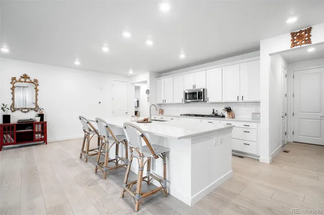 a kitchen with white cabinets and white appliances