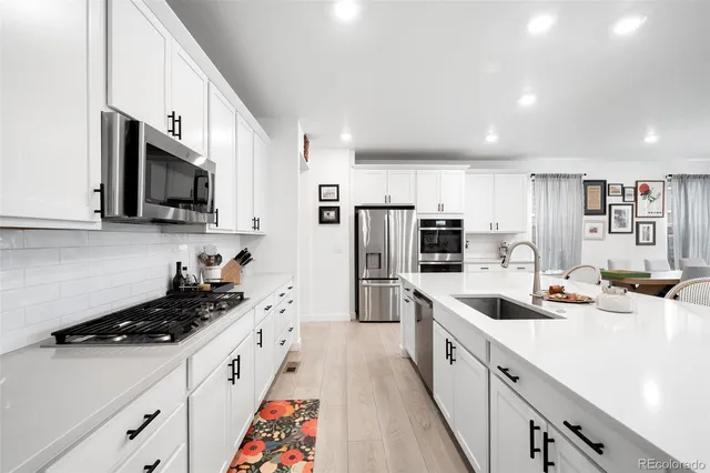 a large kitchen with stainless steel appliances lots of counter space a sink and cabinets