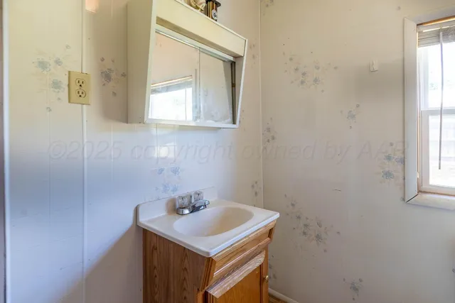 a bathroom with a sink a vanity and a window