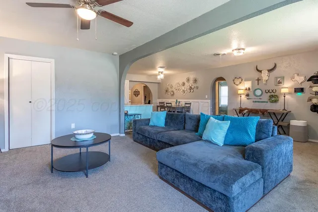 a living room with furniture and a chandelier