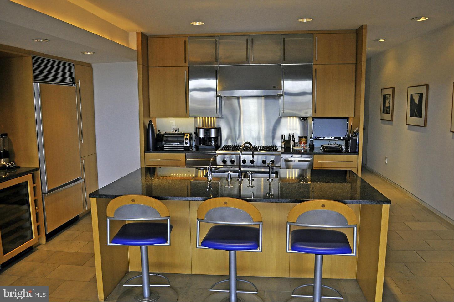 3618 Prospect Street Northwest Washington, DC 20007 - Photo 13 of 30 a kitchen with stainless steel appliances granite countertop a refrigerator a stove a sink counter tops and chairs with wooden floor