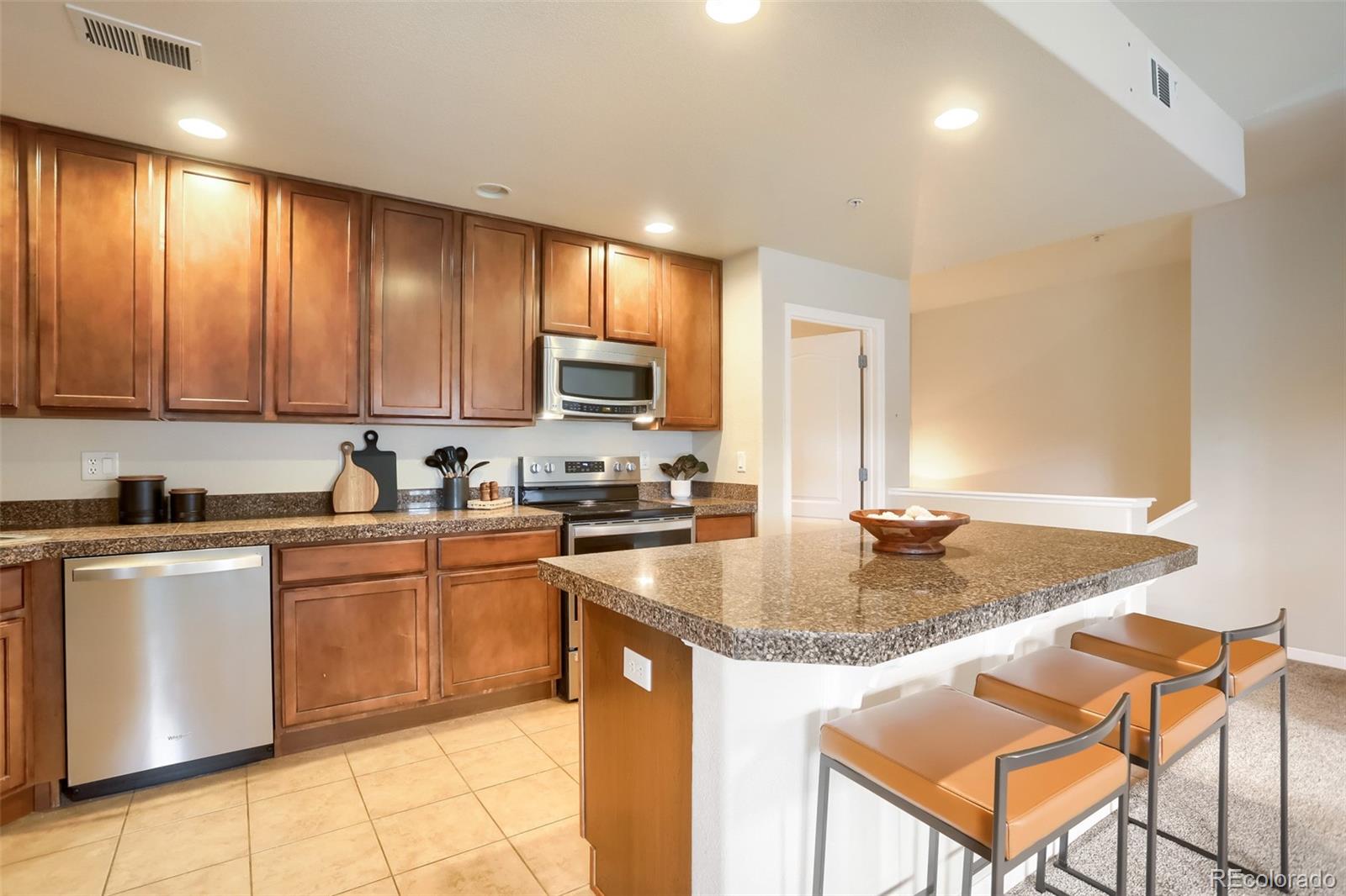 6232 Kilmer Loop, Unit 203 Golden, CO 80403 - Photo 15 of 33 a kitchen with stainless steel appliances granite countertop a sink stove and refrigerator