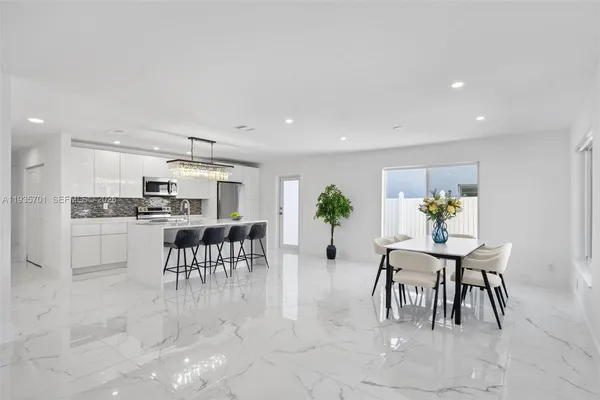 a view of kitchen with kitchen island dining table and chairs