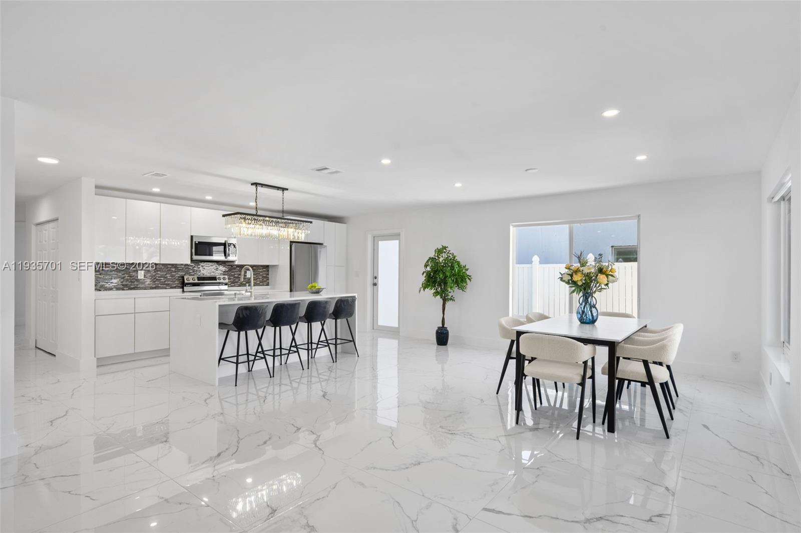 a view of kitchen with kitchen island dining table and chairs