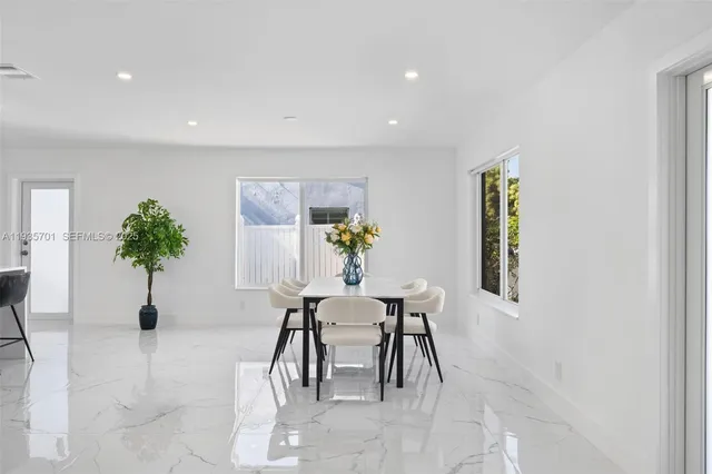 a dining room with furniture and potted plants