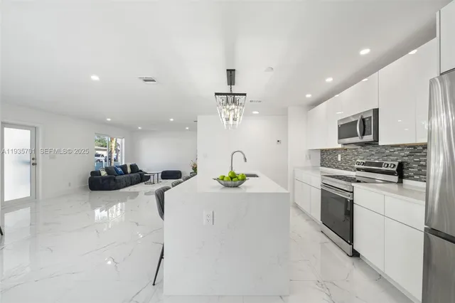 a kitchen with a sink stainless steel appliances and lots of counter top space