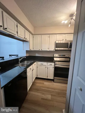 a view of a living room hardwood floor and a kitchen