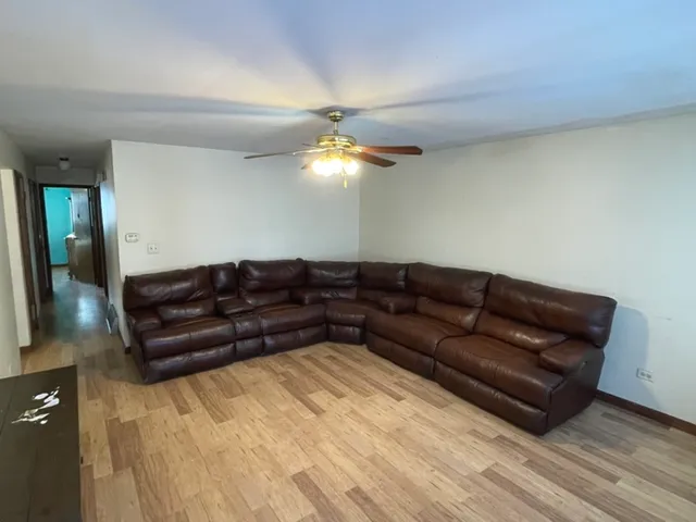 a living room with a couch and a ceiling fan