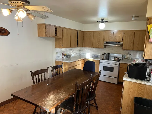 a kitchen with a dining table chairs and a refrigerator
