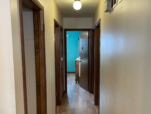 a view of a hallway with wooden floor