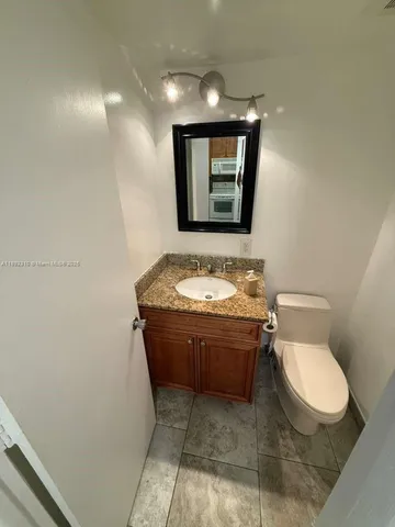 a bathroom with a toilet a sink and mirror